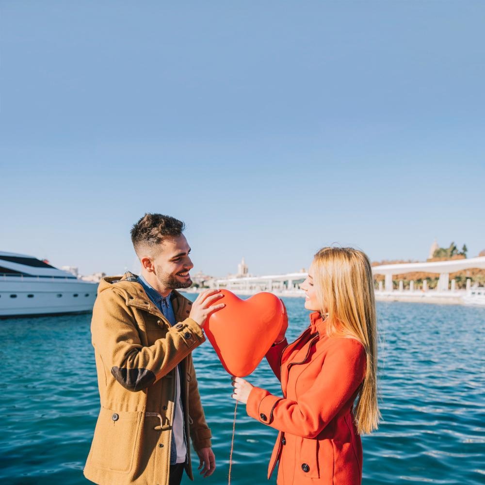 Charming couple with romantic balloon on a yacht