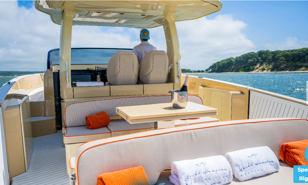 Luxury Yacht Hampton boat cruises past forested shoreline on sunny day.