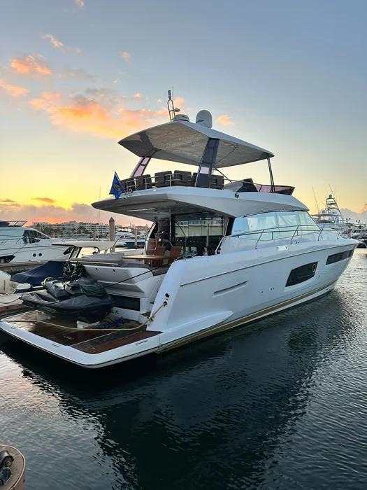 Luxury yacht docked at marina during golden sunset hour.