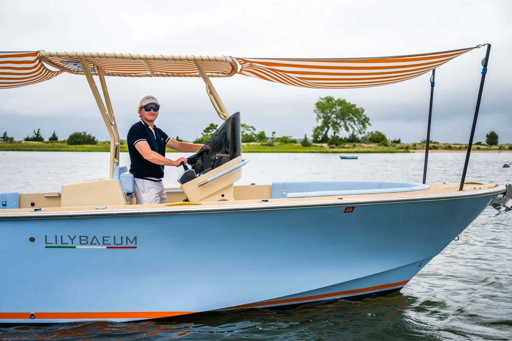 - Light blue motorboat with canopy cruising calm coastal waters.