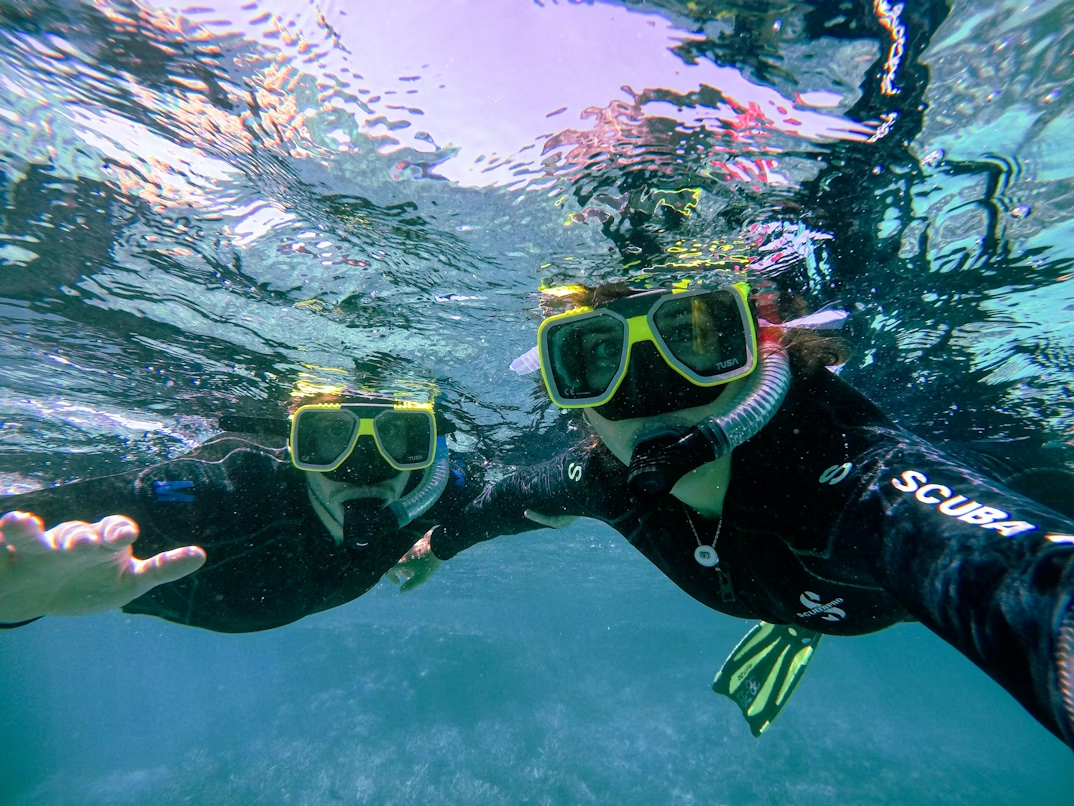Snorkelers exploring clear offshore reef waters together underwater.