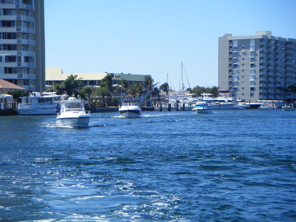 Boats cruising Lake Boca waterway near waterfront condominiums
